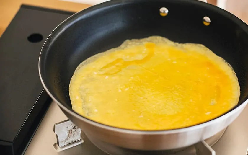 卵液を弱めの中火でフライパンで焼きます。