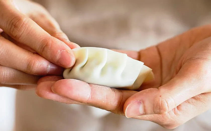 餃子の皮で包んだら、ひだができるように形を整えます