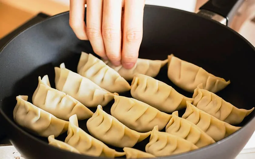 フライパンに油を中火で熱し、餃子を並べます。