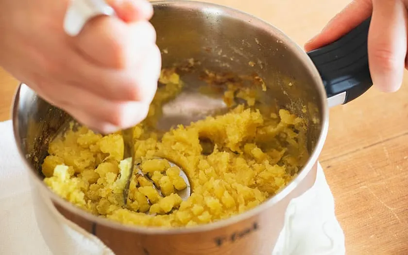 マッシャーでさつまいもをつぶす。